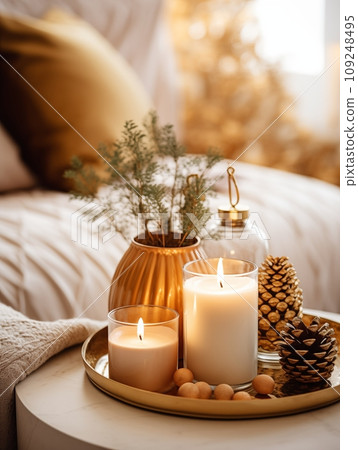 Cozy winter home decor arrangement with burning candles, holiday room interior decorations in white and gold tones Cozy winter home decor arrangement with burning candles, holiday room interior decorations in white and gold tones 109248495