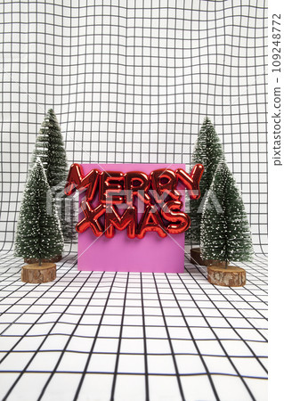 glossy red plastic Christmas ornament featuring a text saying merry xmas and a miniature forest scene 109248772
