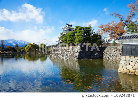 Matsumoto Castle in autumn leaves and the scenery reflected on the water surface, the mountain range of the Northern Alps Matsumoto Castle in autumn leaves and the scenery reflected on the water surface, the mountain range of the Northern Alps 109248871