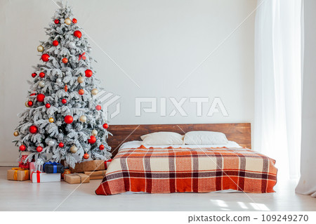 Christmas tree in a white bedroom with bed interior of new year gifts 109249270
