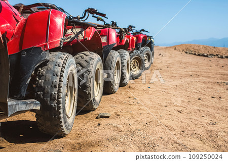 Red quads stand in a row on the shore of the Red Sea. Dahab, Egypt. Red quads stand in a row on the shore of the Red Sea. Dahab, Egypt. 109250024