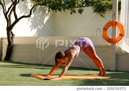 Flexible Woman Stretching on Yoga Mat Outdoors 109250355