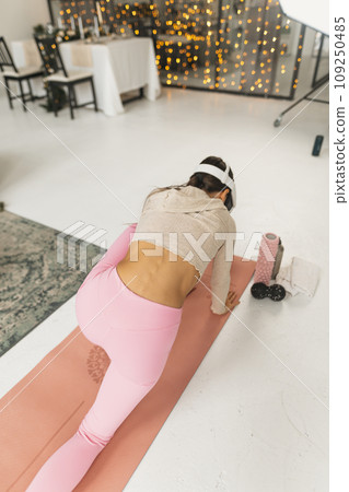 Engaging in arm stretches during home workout sessions using a virtual reality headset amid the Christmas festivities. 109250485