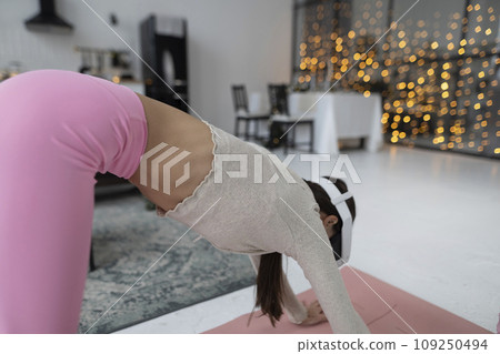 Yoga practice indoors with virtual reality technology during the Christmas period. 109250494