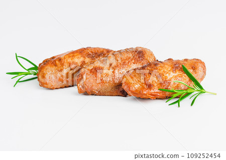 Chicken wings fried until half cooked, semi-finished product with fresh herbs on a white background. Fast food. Quick cooking at home. Copy space.Fast cooking.Fast homemade food. 109252454