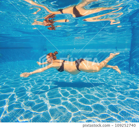 Pregnant serenity submerged a woman gracefully dives into the pool, celebrating the beauty of pregnancy with aquatic elegance 109252740