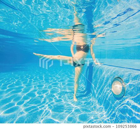 Embracing aquatic fitness, a pregnant woman demonstrates strength and serenity in underwater aerobics, creating a serene and empowering image in the pool Embracing aquatic fitness, a pregnant woman demonstrates strength and serenity in underwater aerobics, creating a serene and empowering image in the pool 109253866