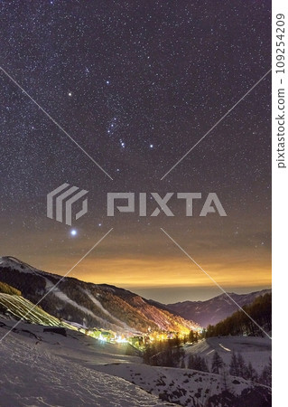 Starry sky above snowy winter mountains, ski resort town Starry sky above snowy winter mountains, ski resort town 109254209