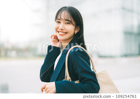 Businesswoman with office building in the background Businesswoman with office building in the background 109254761