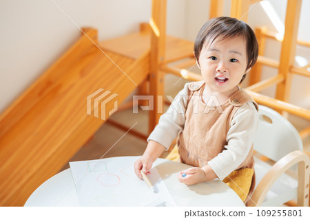 Infant drawing with crayons 109255801