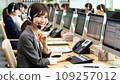 A Japanese female employee wearing a suit and smiling while working at a call center 109257012