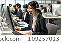 A Japanese female employee wearing a suit and smiling while responding to customers at a call center 109257013