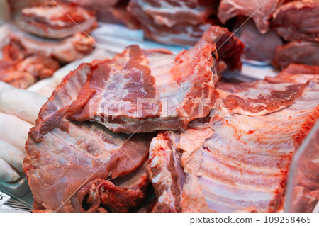 Raw pork rib tips in packing tray on glass window refrigerator of meat shop Raw pork rib tips in packing tray on glass window refrigerator of meat shop 109258465