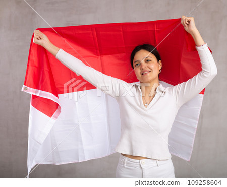Pretty young female student holding Indonesia flag in her hands 109258604