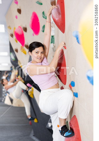 Young asian woman practicing rock climbing on climbing wall 109258860