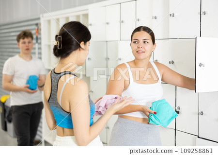 Two young women talking near lockers in locker room 109258861