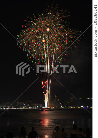 Colorful fireworks celebration with people and the city night light background at the seaside. Colorful fireworks celebration with people and the city night light background at the seaside. 109260141
