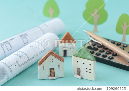 Image of thinking about purchasing a home using a miniature house and blueprints Image of thinking about purchasing a home using a miniature house and blueprints 109260325