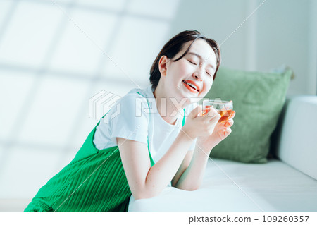 年輕女子在房間裡喝茶。 109260357