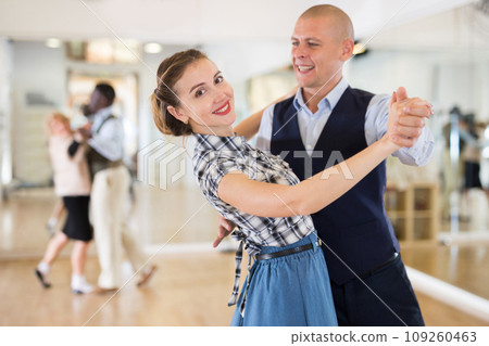 Man and woman performing ballroom dance in dancing room 109260463