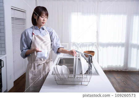 Woman wiping dishes in the kitchen 109260573
