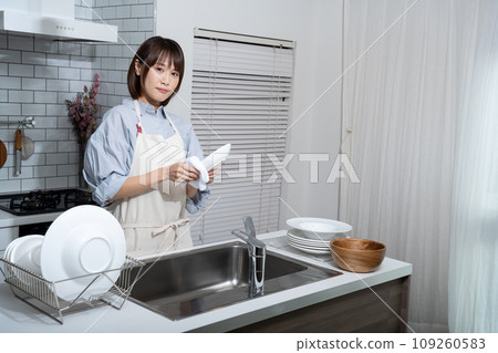 Woman wiping dishes in the kitchen 109260583