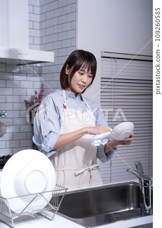 Woman wiping dishes in the kitchen 109260585