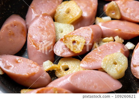 Stir-fried fish sausage with garlic, cooking scene. 109260621