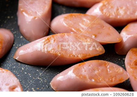 A cooking scene where fish sausage (diagonally cut) is stir-fried in a frying pan. A cooking scene where fish sausage (diagonally cut) is stir-fried in a frying pan. 109260628