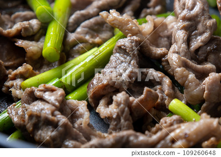 Stir-fried beef and garlic sprouts, cooking scene. 109260648