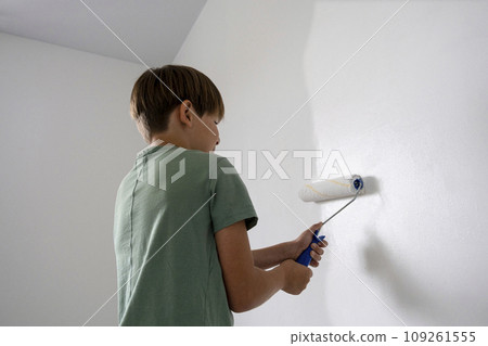 children paint the wall with a roller. teenagers spend time together helping to make repairs. children paint the wall with a roller. teenagers spend time together helping to make repairs. 109261555