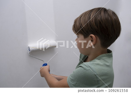 children paint the wall with a roller. teenagers spend time together helping to make repairs. children paint the wall with a roller. teenagers spend time together helping to make repairs. 109261558