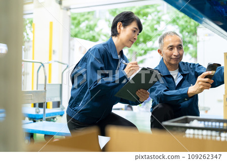 中年男女工人在倉庫檢查物品 109262347