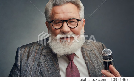 A fat old man with white hair and glasses answers an interview wearing an elegant suit. 109264653