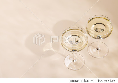 Two champagne glasses on a beige Two champagne glasses on a beige 109266186