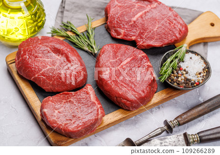 Raw beef fillet steaks on a board, fresh and uncooked Raw beef fillet steaks on a board, fresh and uncooked 109266289