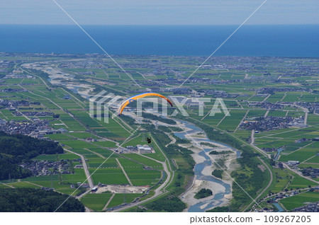 Paraglider flying from Shishiwa Kogen and view of Kanazawa Plain and Tedori River Alluvial Fan 109267205