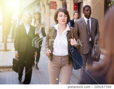 Portrait of hurrying woman among passers 109267390