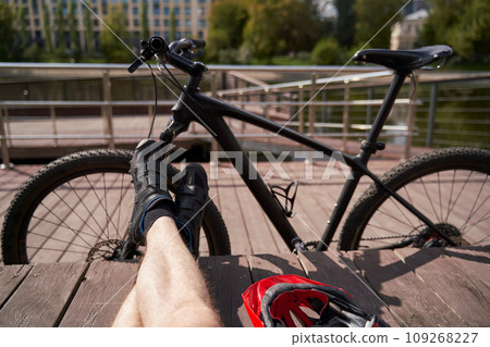 Legs of a man on the background of a bicycle. Relaxation while cycling around the city. Legs of a man on the background of a bicycle. Relaxation while cycling around the city. 109268227