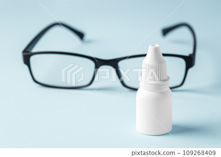 Eye dropper with eyeglasses on blue background 109268409