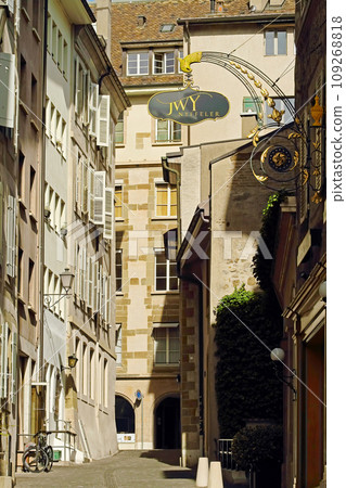 Fragment of a street in the old center of Geneva with old houses exteriors and windows with old wooden shutters pattern. Fragment of a street in the old center of Geneva with old houses exteriors and windows with old wooden shutters pattern. 109268818
