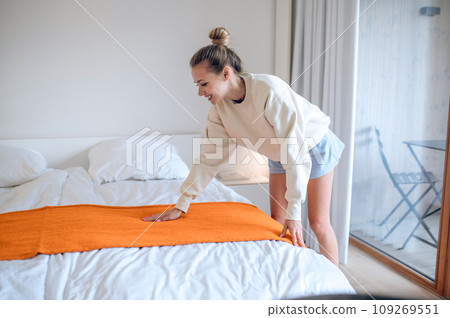 Girl in white making bed in the morning Girl in white making bed in the morning 109269551