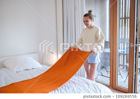 Girl in white making bed in the morning Girl in white making bed in the morning 109269556
