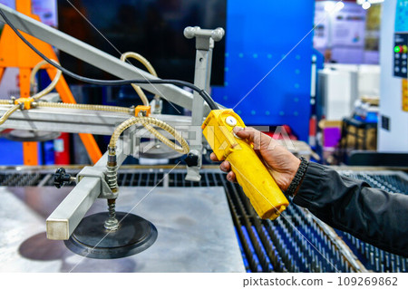 A worker is pressing a steel plan control button to enter the steel cutting process in the industrial factory 109269862