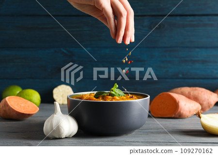 Sweet potato puree in bowl, vegetables, hand and spices on wooden background 109270162