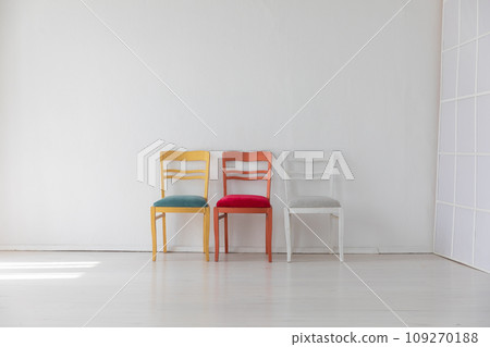 Three colorful vintage chairs in white room interior Three colorful vintage chairs in white room interior 109270188