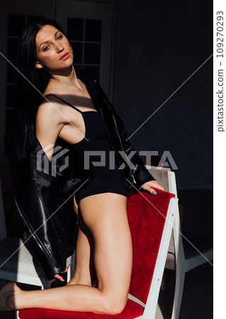 Fashionable slender brunette woman sitting on an old chair Fashionable slender brunette woman sitting on an old chair 109270293
