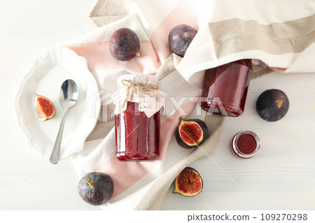 Figs, jars of jam and towel on light background, top view 109270298
