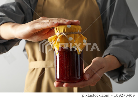 Jar with fig jam in hands on white background 109270409