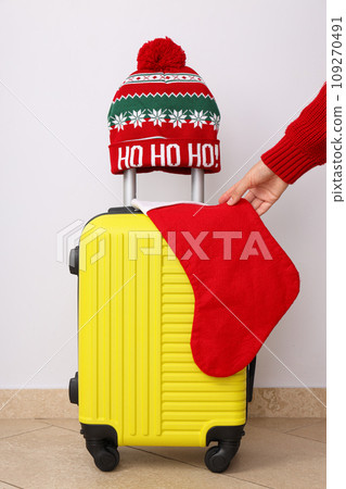 A suitcase with a winter hat and a New Year's stocking 109270491